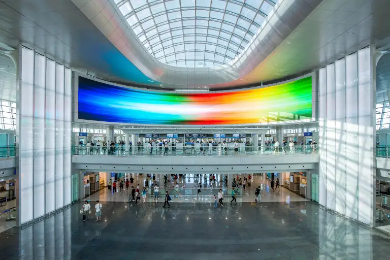 Large airport terminal digital signage board above the check-in area