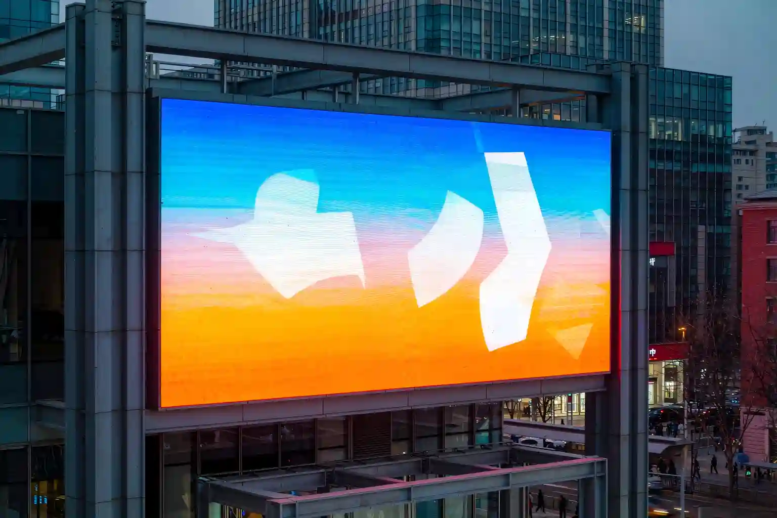 Outdoor LED screen for advertising on a building rooftop at dusk, bright enough to stay vivid in low light